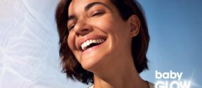Woman laughing in sunlight with glowing, hydrated skin, illustrating Teoxane babyGLOW at Regents Park Aesthetics Birmingham.